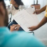 Tim profesional menganalisis laporan kinerja dalam rapat kantor
